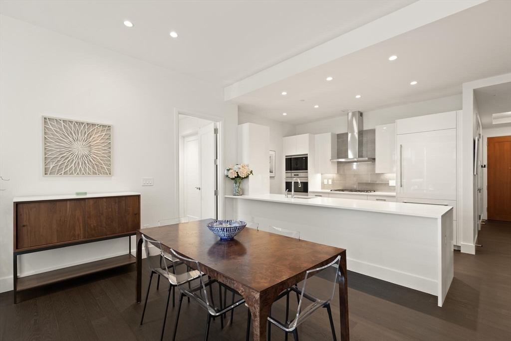 50 Liberty Drive, Unit 11L Boston, MA 02210 - Photo 7 of 40 a kitchen with stainless steel appliances kitchen island granite countertop a dining table chairs and a refrigerator