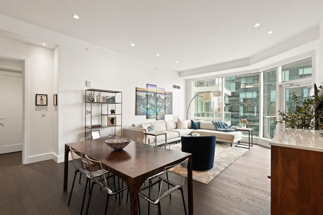 a living room with furniture a large window and wooden floor