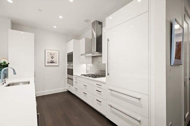 a kitchen with cabinets and wooden floor