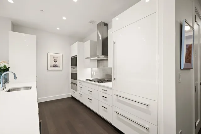 a kitchen with cabinets and wooden floor