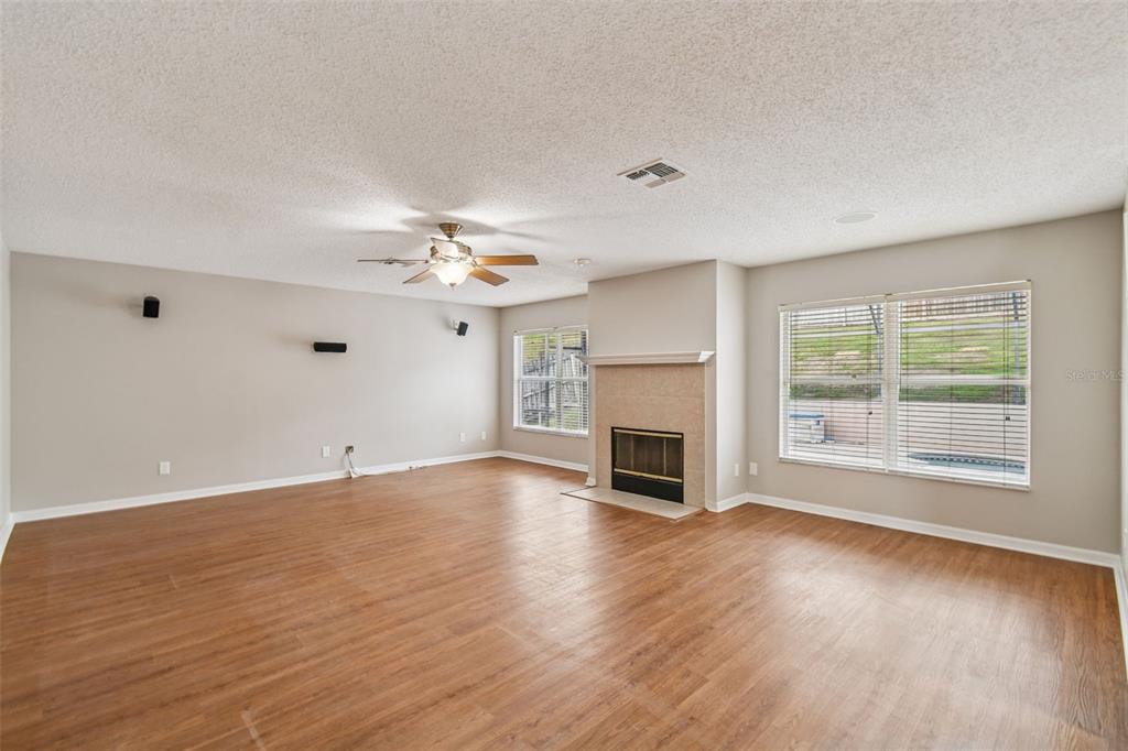1854 Ridge Valley Street Clermont, FL 34711 - Photo 11 of 73 an empty room with wooden floor fireplace and windows