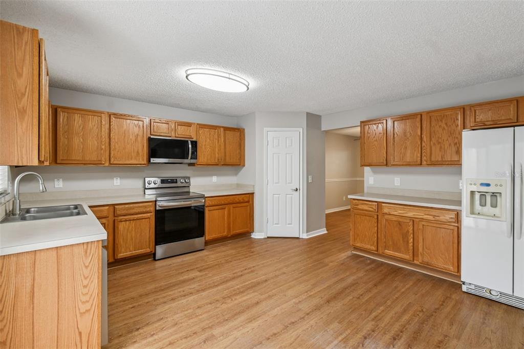 1854 Ridge Valley Street Clermont, FL 34711 - Photo 18 of 73 a kitchen with stainless steel appliances granite countertop a sink dishwasher stove and refrigerator