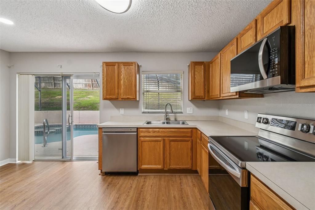 1854 Ridge Valley Street Clermont, FL 34711 - Photo 19 of 73 a kitchen with stainless steel appliances a sink cabinets and wooden floor