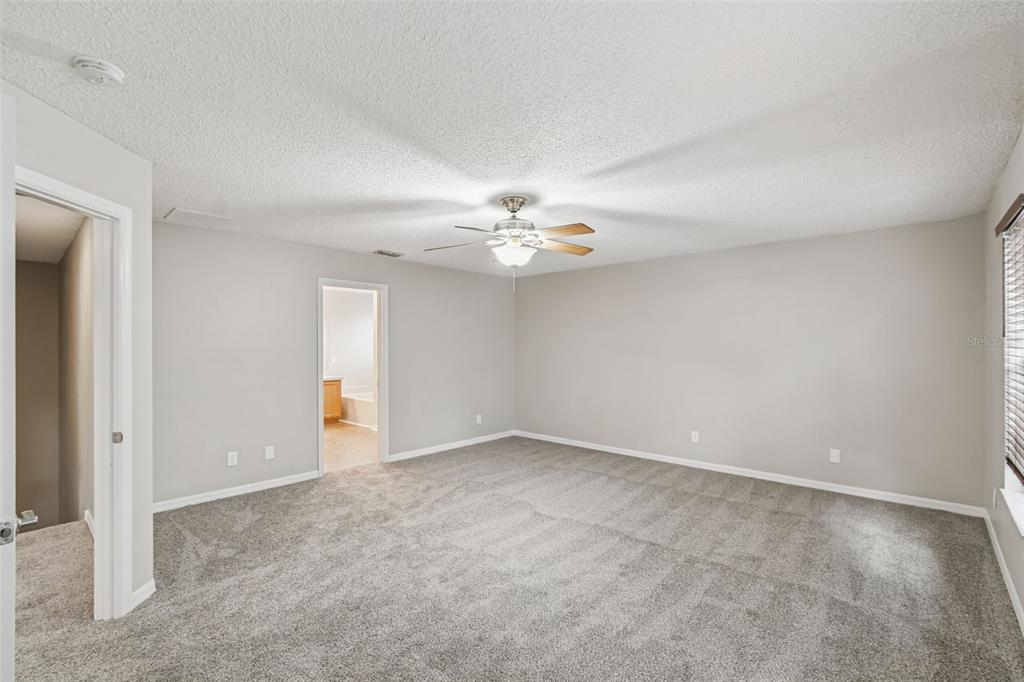 1854 Ridge Valley Street Clermont, FL 34711 - Photo 30 of 73 an empty room with a chandelier fan and windows