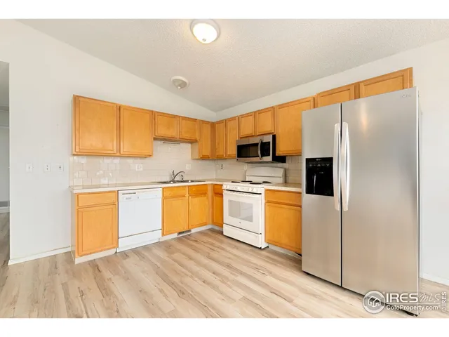 a kitchen with a refrigerator sink and cabinets
