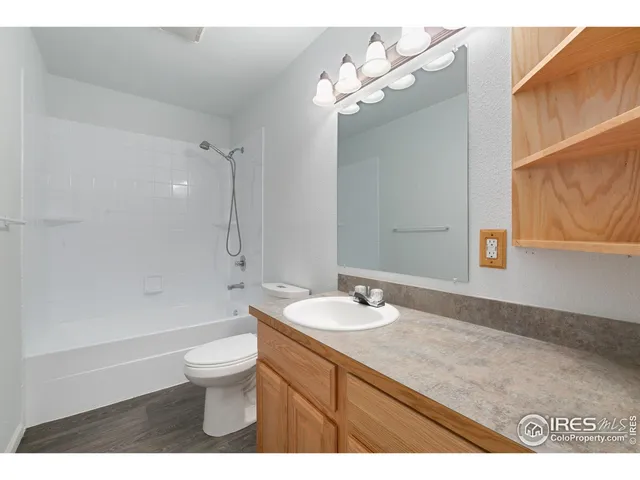 a bathroom with a sink a toilet a light fixture and a shower