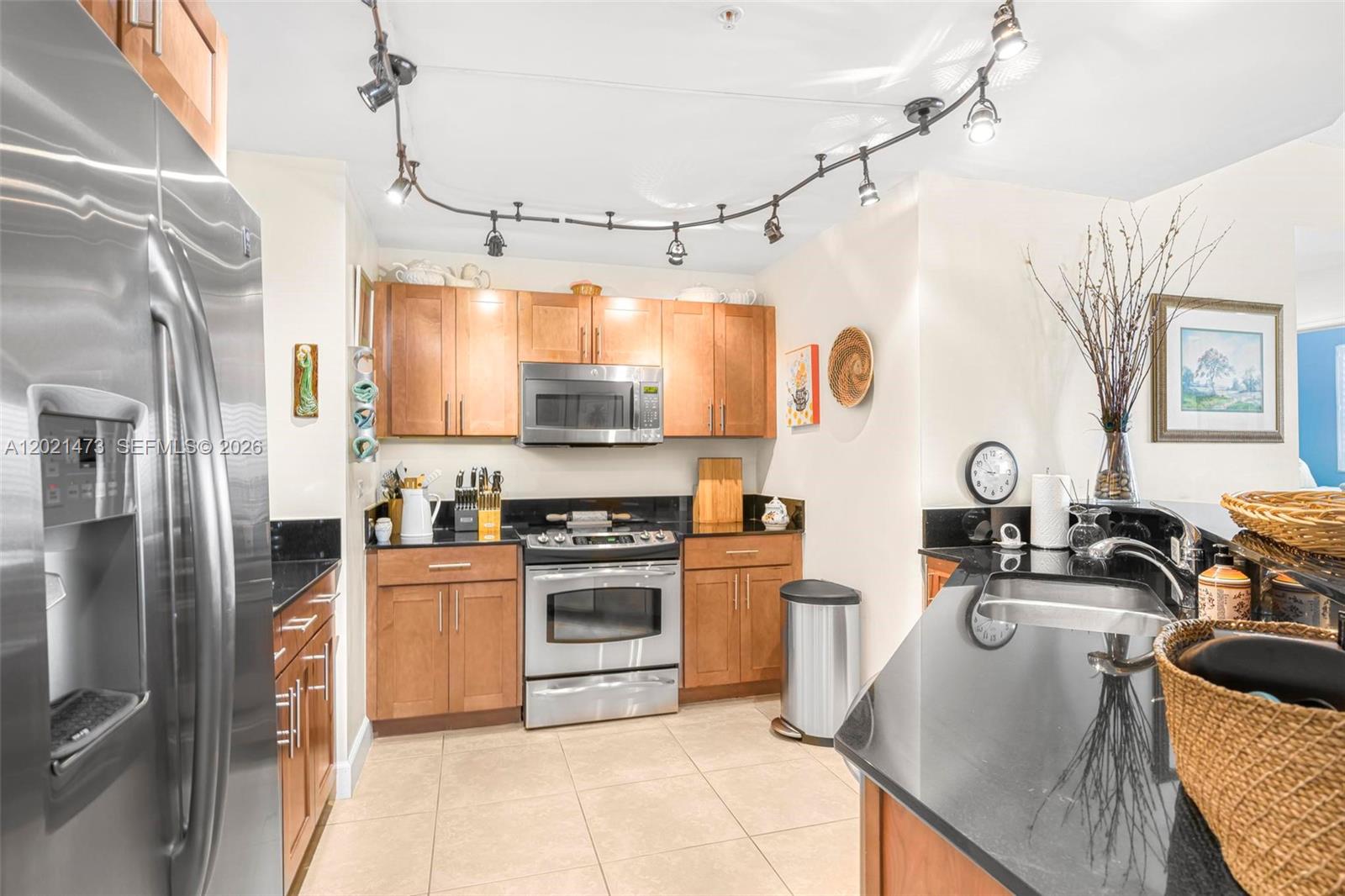 8395 Southwest 73rd Avenue, Unit 710 Miami, FL 33143 - Photo 14 of 32 a kitchen with stainless steel appliances granite countertop a sink stove and refrigerator