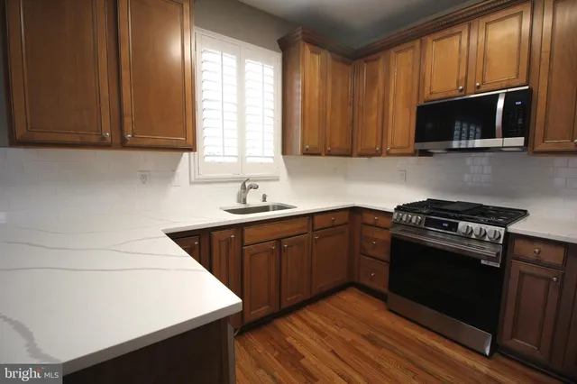 a kitchen with stainless steel appliances a stove a microwave and sink