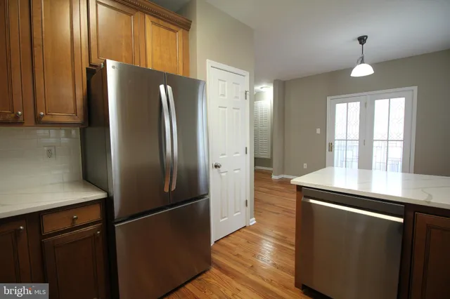 a kitchen with stainless steel appliances granite countertop a refrigerator a sink and a stove