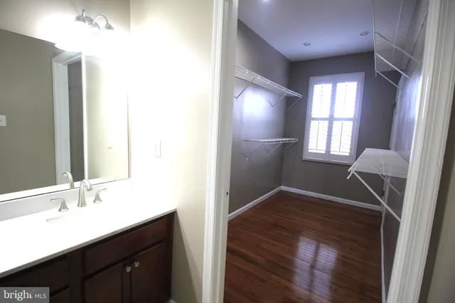 a view of hallway with a sink and a mirror
