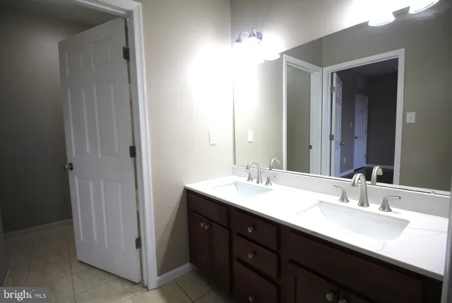 a bathroom with a double vanity sink and a mirror