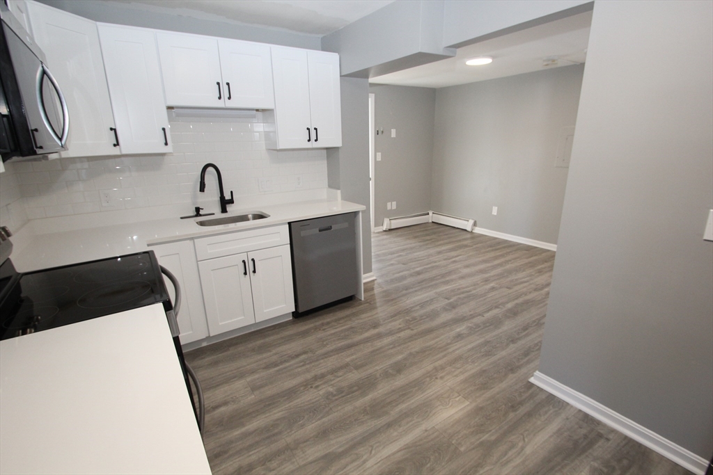299 Main Street, Unit 2 North Reading, MA 01864 - Photo 12 of 35 a kitchen with a sink a stove and cabinets