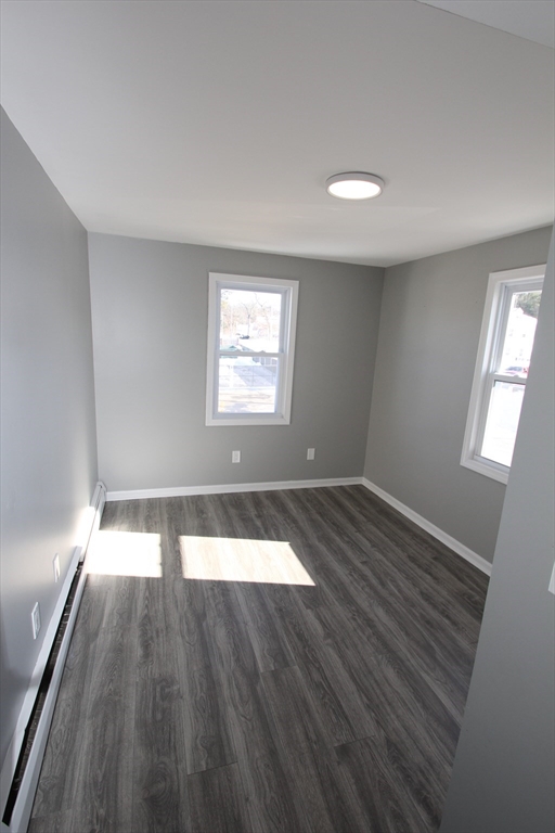 299 Main Street, Unit 2 North Reading, MA 01864 - Photo 13 of 35 an empty room with wooden floor and windows