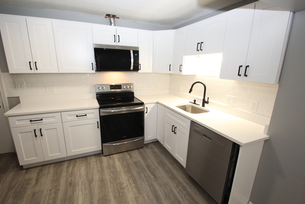 299 Main Street, Unit 2 North Reading, MA 01864 - Photo 16 of 35 a kitchen with sink a microwave and cabinets
