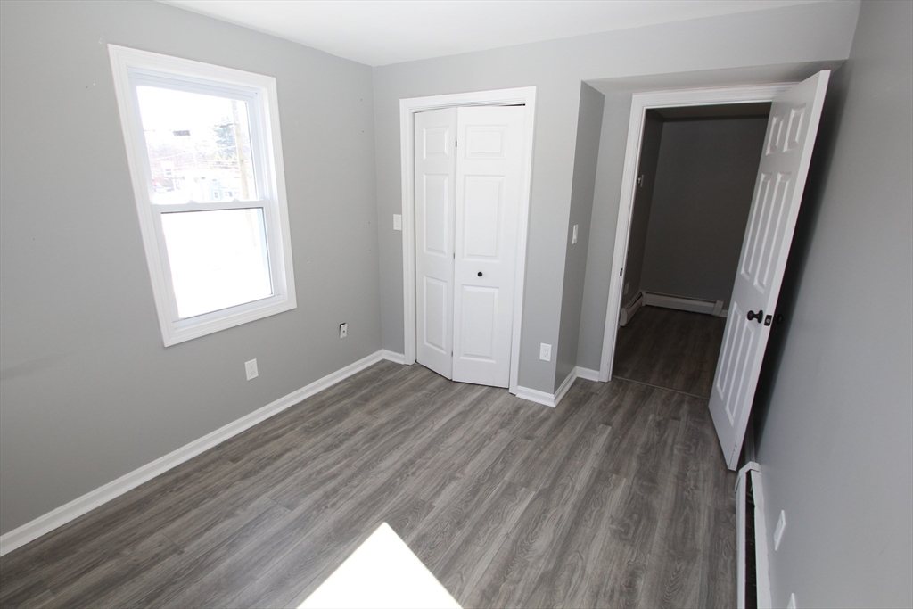 299 Main Street, Unit 2 North Reading, MA 01864 - Photo 17 of 35 an empty room with wooden floor and windows