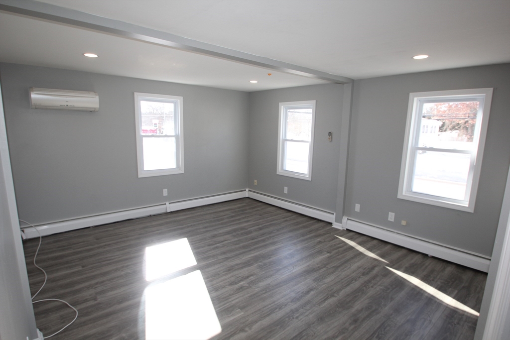 299 Main Street, Unit 2 North Reading, MA 01864 - Photo 27 of 35 a view of an empty room with wooden floor and window