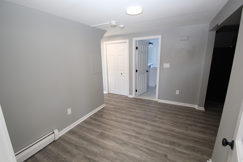 299 Main Street, Unit 2 North Reading, MA 01864 - Photo 7 of 35 a view of an empty room with wooden floor and a window