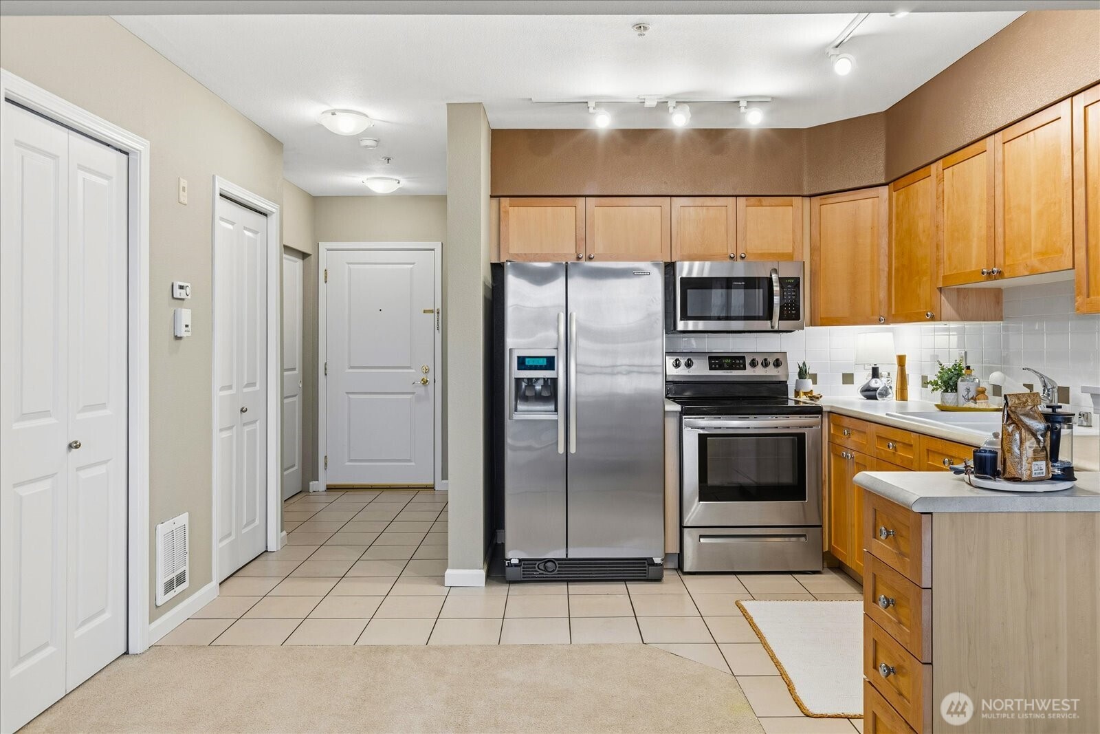 1525 Northwest 57th Street, Unit 429 Seattle, WA 98107 - Photo 10 of 26 a kitchen with stainless steel appliances granite countertop a refrigerator and a sink