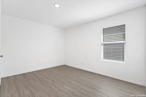 a view of a room that has wooden floor and a window