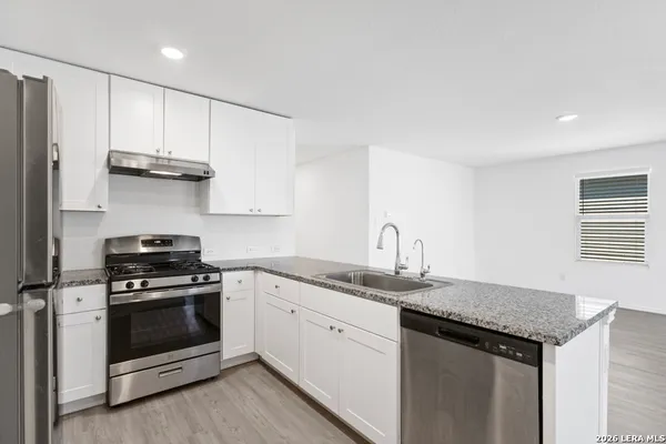 a kitchen with stainless steel appliances granite countertop a stove and a sink