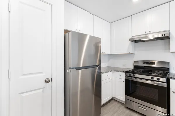 a white refrigerator freezer and a stove sitting inside of a kitchen