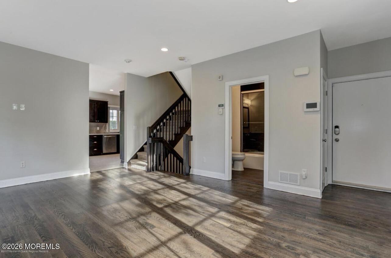 1-3 Church Street Matawan, NJ 07747 - Photo 23 of 28 a view of an empty room with wooden floor and stairs