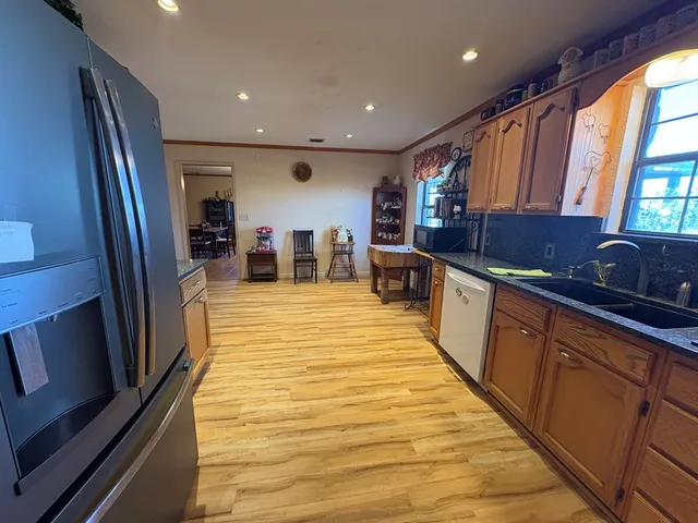 a large kitchen with stainless steel appliances granite countertop a refrigerator and a sink