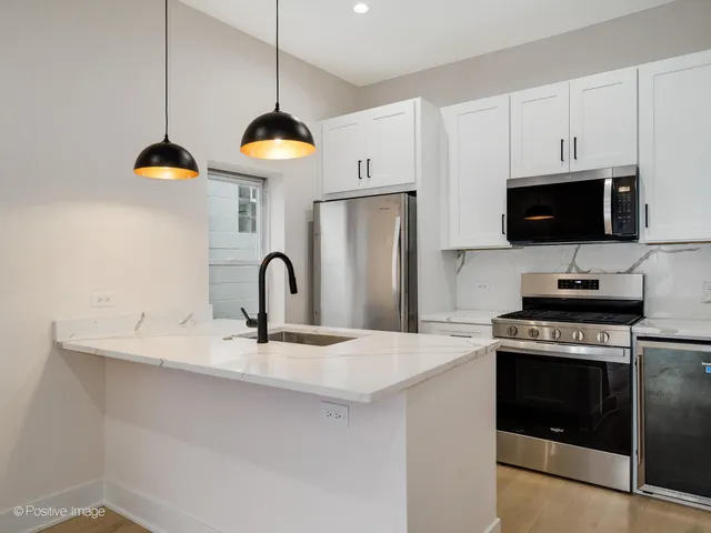 a kitchen with stainless steel appliances granite countertop a stove a sink and a microwave