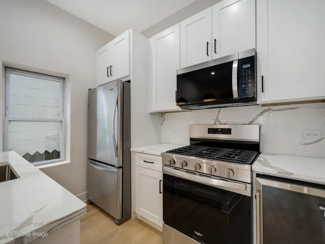 a kitchen with stainless steel appliances a stove a microwave and a refrigerator