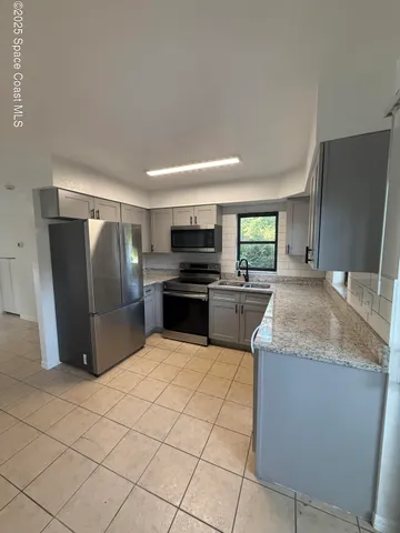 a kitchen with stainless steel appliances granite countertop a refrigerator sink and stove