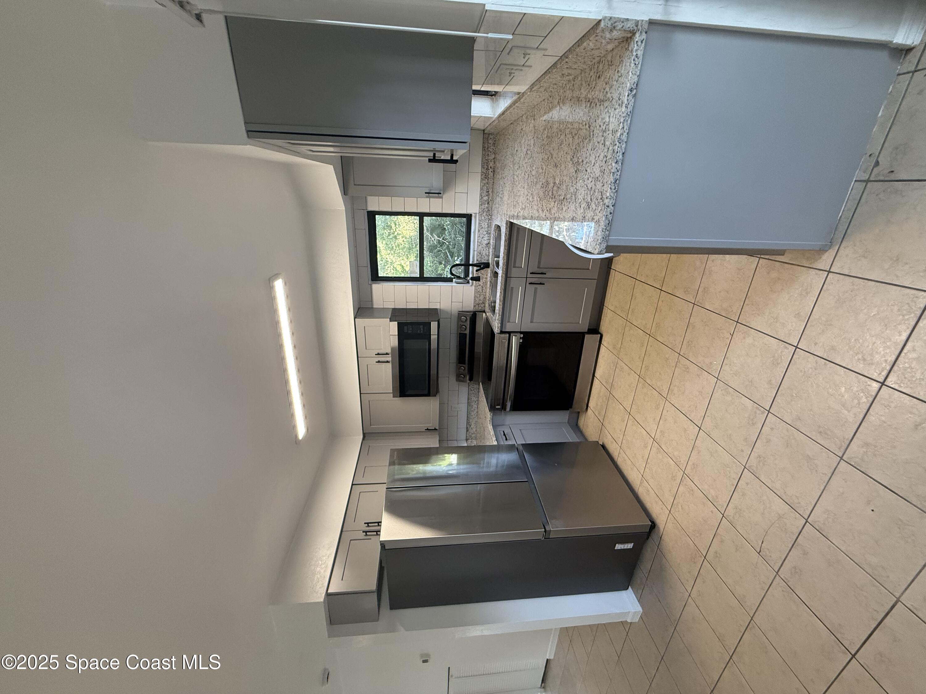 1971 Agora Circle Southeast, Unit 101 Palm Bay, FL 32909 - Photo 1 of 5 a kitchen with stainless steel appliances granite countertop a refrigerator sink and stove