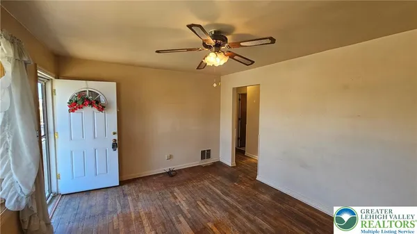 a view of empty room with wooden floor