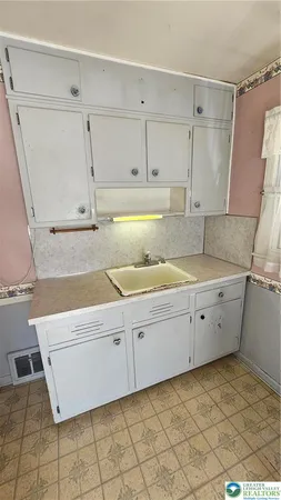 a kitchen with a sink window and cabinets