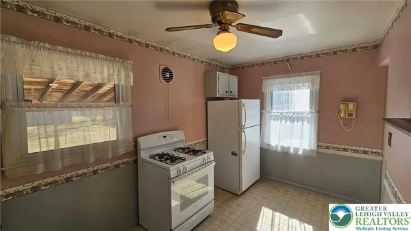 a kitchen with stainless steel appliances granite countertop a refrigerator a stove and a window