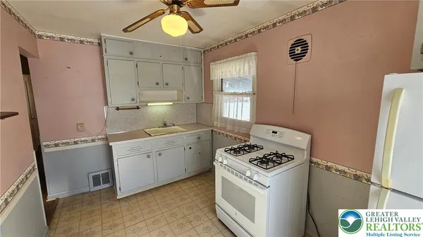 a kitchen with granite countertop a sink cabinets stainless steel appliances and a window