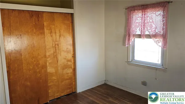 a view of a small space with wooden floor and a window