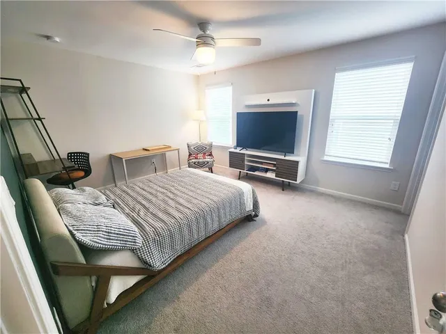 a bedroom with bed tv and window