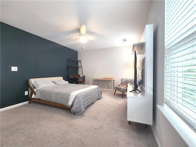 a bedroom with bed and a large window