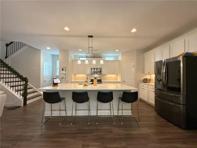 a kitchen with a dining table chairs and wooden floor