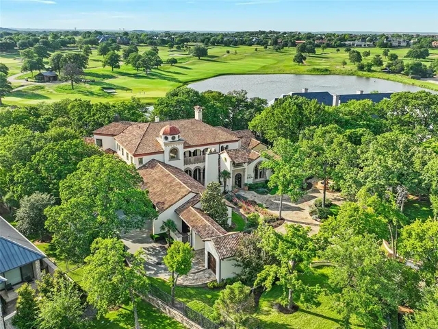an aerial view of a house with a yard and lake view