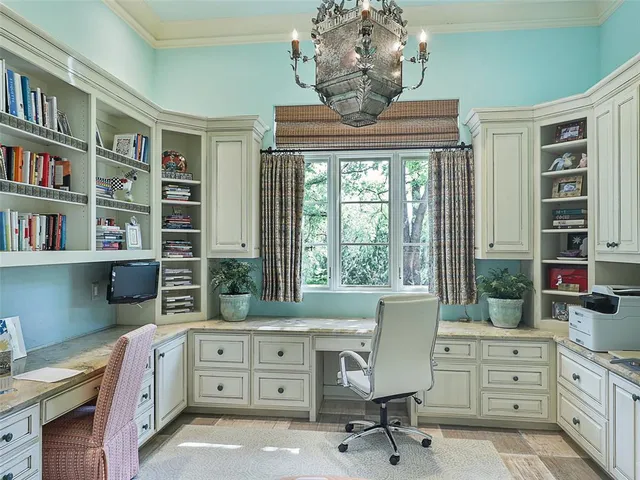 a view of a workspace with furniture and a window