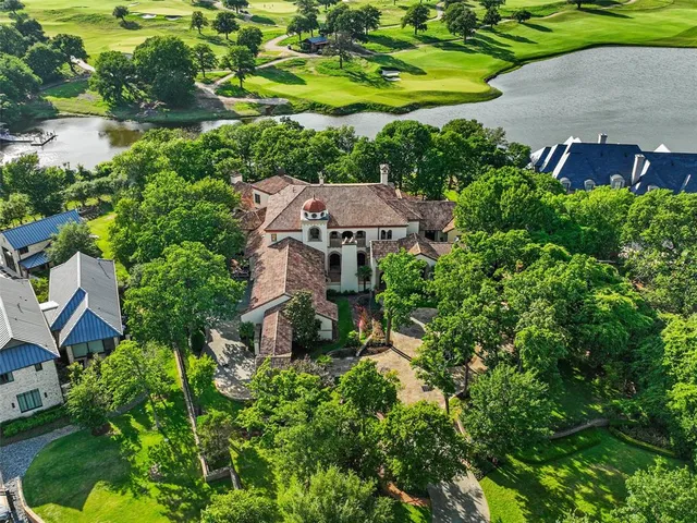 an aerial view of a house with a yard and large trees