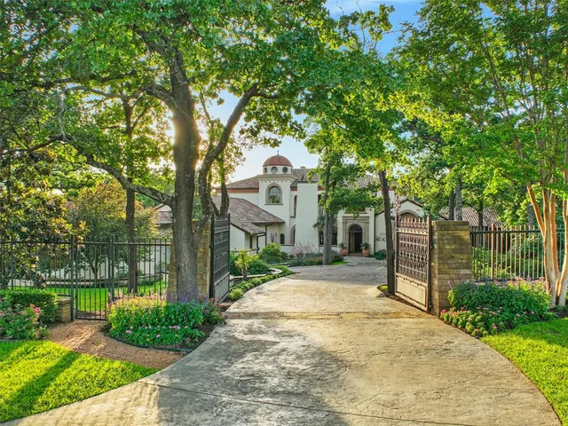 a front view of a house with a yard and potted plants