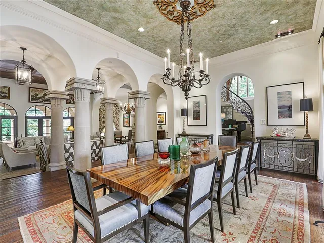 a dining room with wooden floor a chandelier a wooden table and chairs