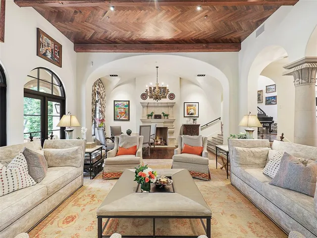 a living room with furniture chandelier and a large window