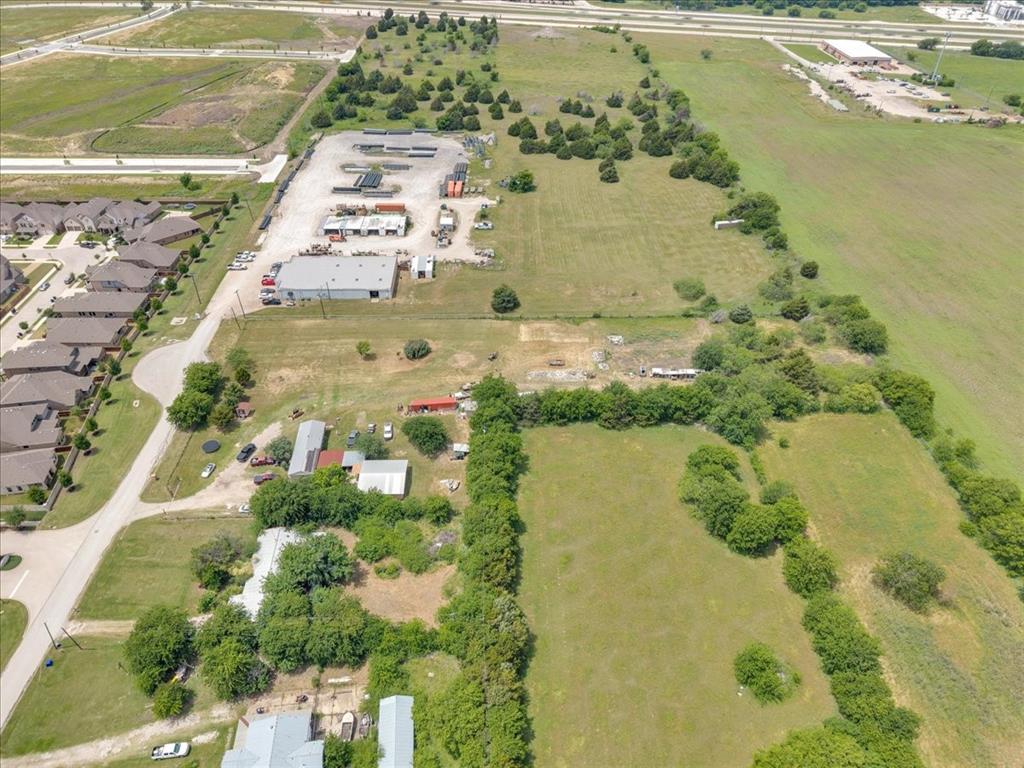 2511 Mathis Road Mansfield, TX 76063 - Photo 20 of 23 Land parcel featuring open fields, scattered mature trees, and existing structures including multiple buildings with gray roofs and various outbuildings