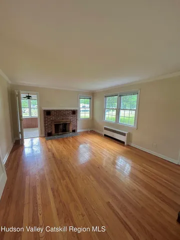an empty room with windows and fireplace