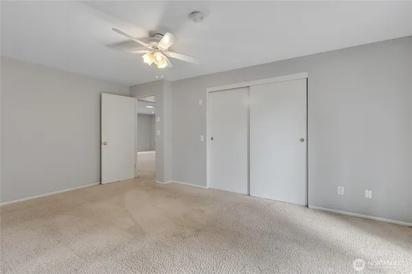 a view of an empty room with a ceiling fan