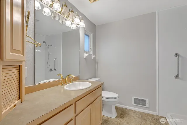 a bathroom with a sink a toilet and shower