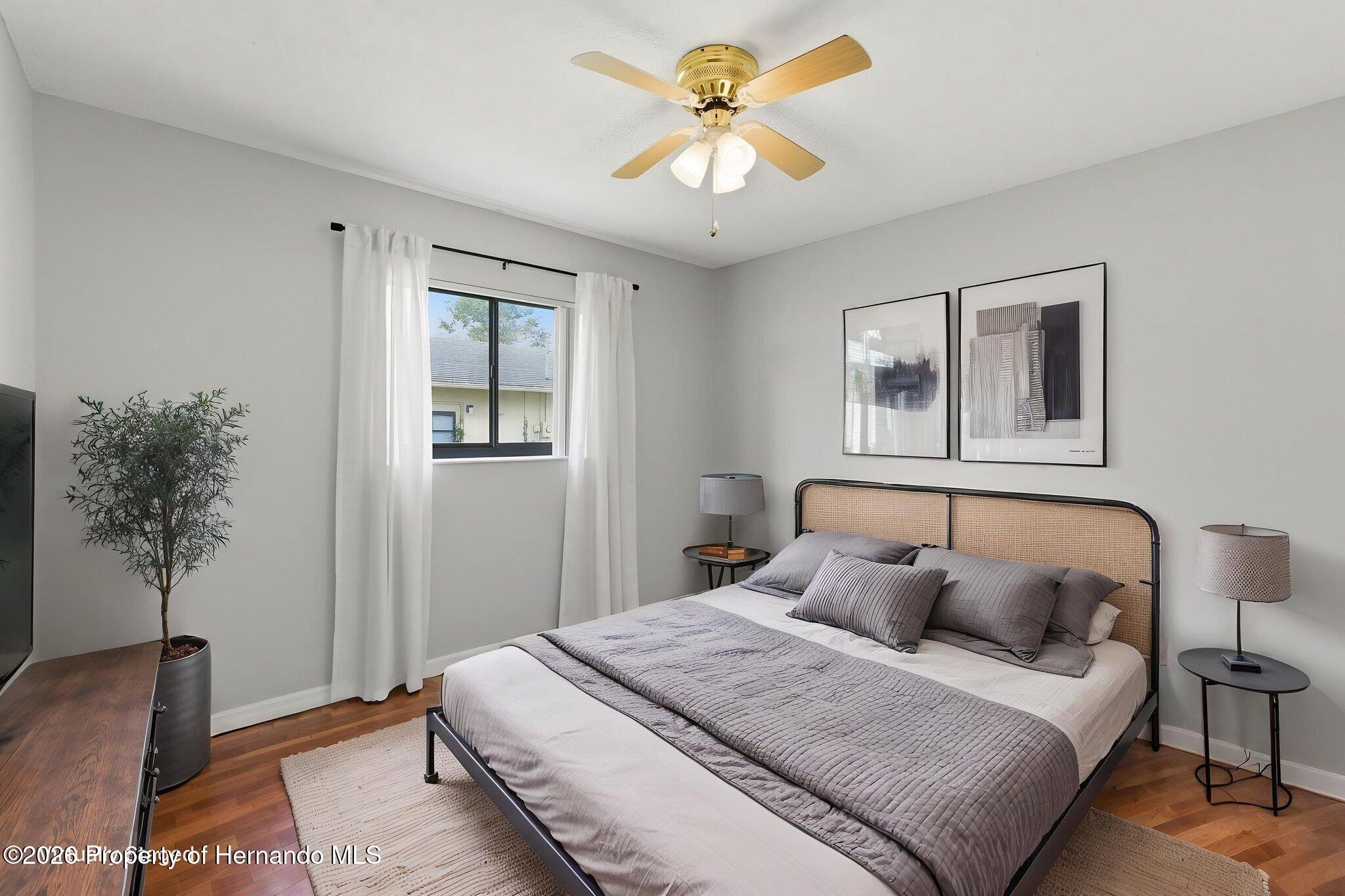 4966 Keysville Avenue Spring Hill, FL 34608 - Photo 32 of 50 a bedroom with a bed and a chandelier
